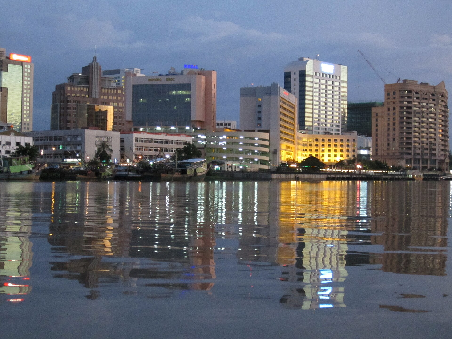 The Kuching Waterfront and the Sarawak River at sunset, boats crossing below the old town